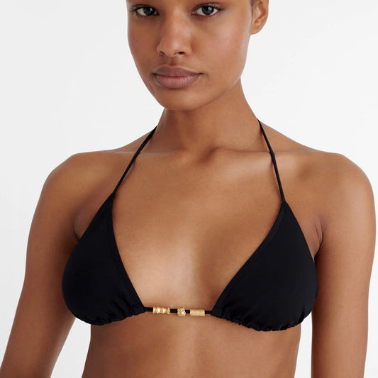 Woman wearing a black bikini top with gold accents available at LaSource in Darien, New Canaan and Westport